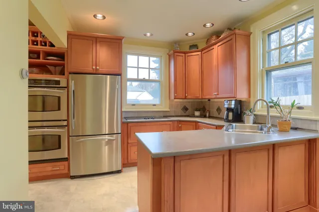 a kitchen with stainless steel appliances granite countertop a sink and a refrigerator