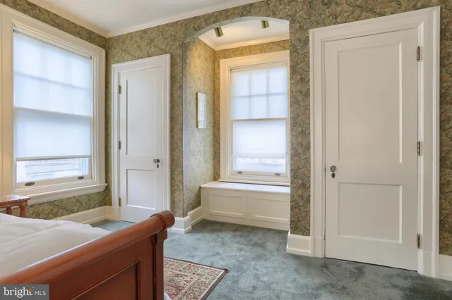 a bedroom with a bed and a lamp on the dresser