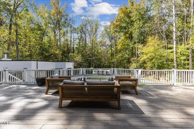 a roof deck with couches and wooden fence