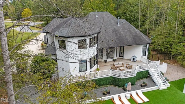 a view of a house with pool and chairs
