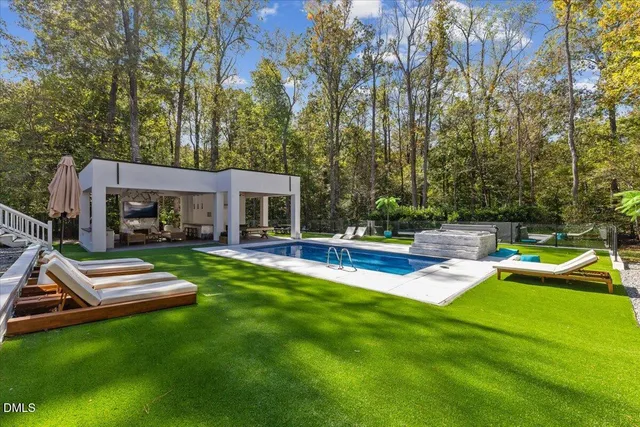 a view of a house with a yard patio and swimming pool