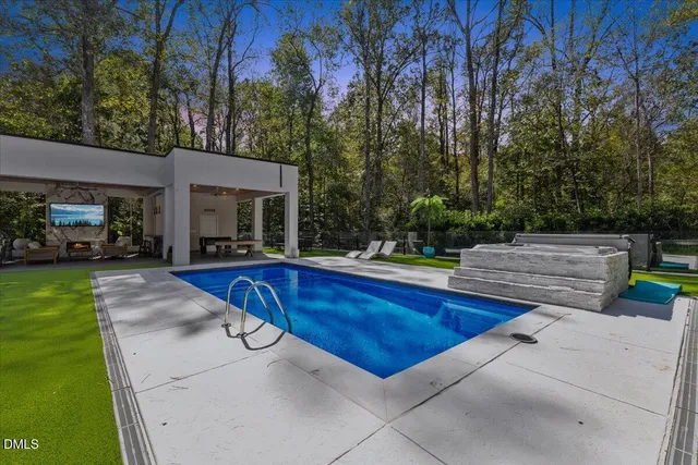 a view of house with swimming pool and sitting area