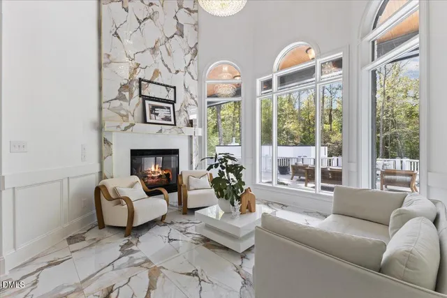 a living room with furniture a fireplace and a large window