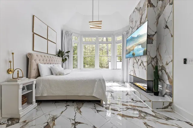 a spacious bedroom with a bed a window and a flat screen television