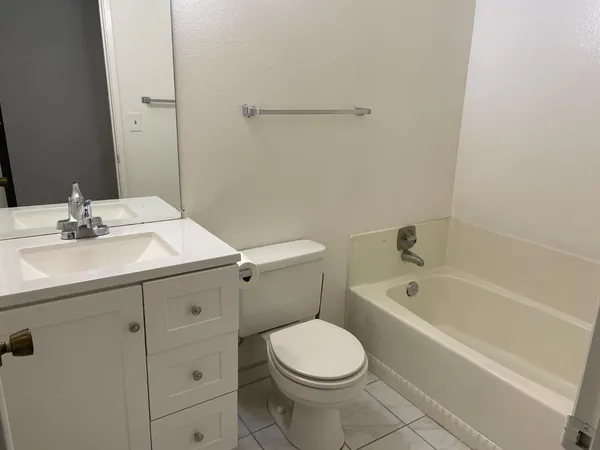 a view of an empty room with wooden floor and closet