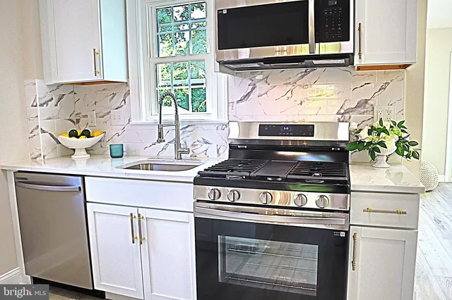 a stove top oven sitting inside of a kitchen