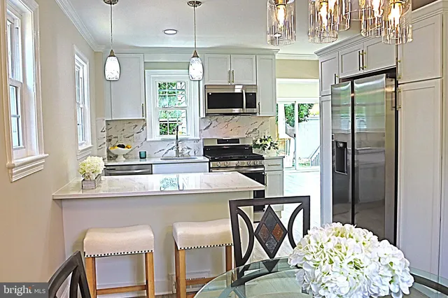 a kitchen with stainless steel appliances a table chairs and chandelier