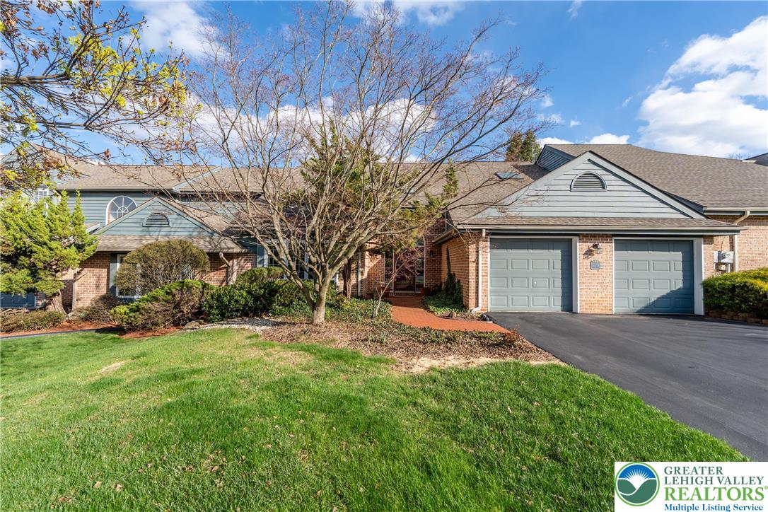 a front view of a house with a garden and yard