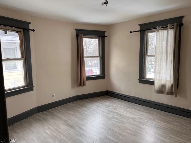 54 Gaston Avenue, Unit 2 Raritan, NJ 08869 - Photo 13 of 16 an empty room with wooden floor and windows