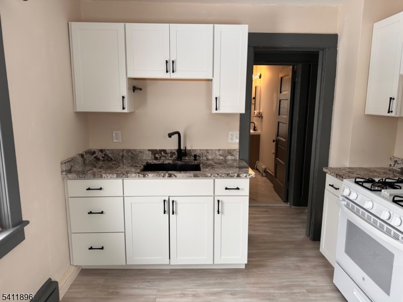 54 Gaston Avenue, Unit 2 Raritan, NJ 08869 - Photo 3 of 16 a kitchen with granite countertop a sink stove and cabinets