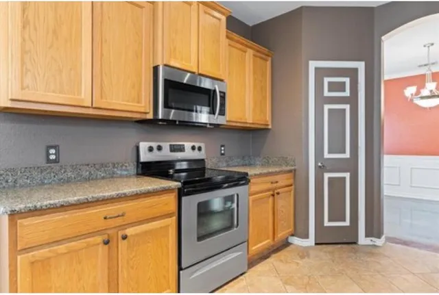 a kitchen with stainless steel appliances granite countertop white cabinets and a stove