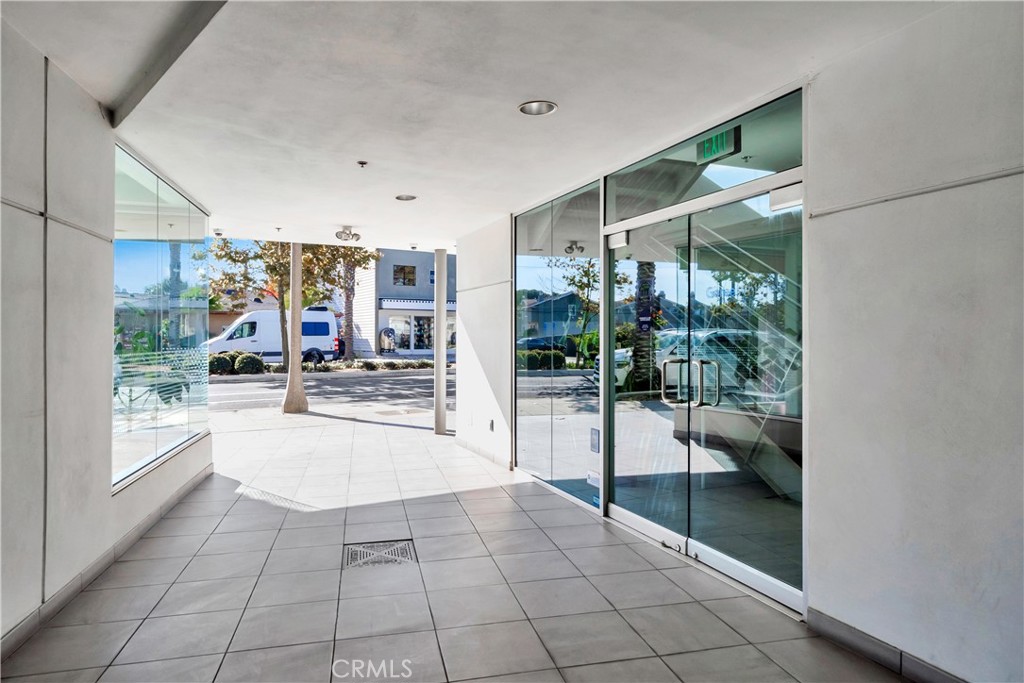 24691 Del Prado Avenue, Unit 100 Dana Point, CA 92629 - Photo 15 of 31 a hallway with a glass door and shower