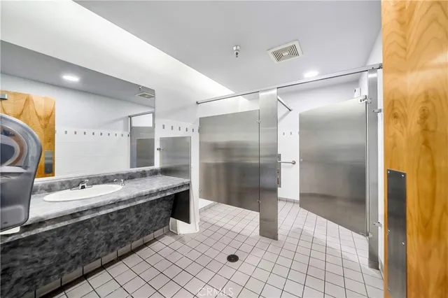 a bathroom with a double vanity sink mirror and shower