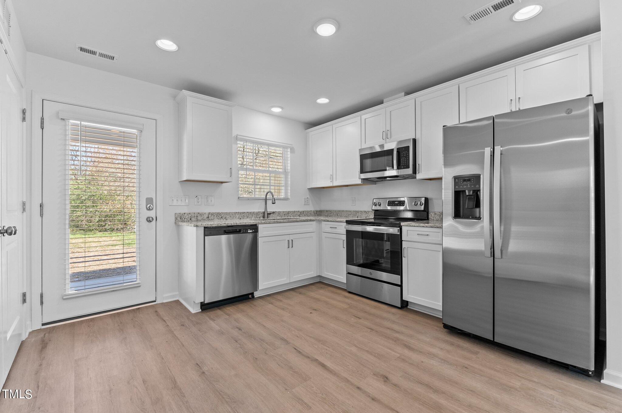 207 South Nash Street, Unit AB Bunn, NC 27508 - Photo 2 of 25 a kitchen with stainless steel appliances a refrigerator sink and microwave