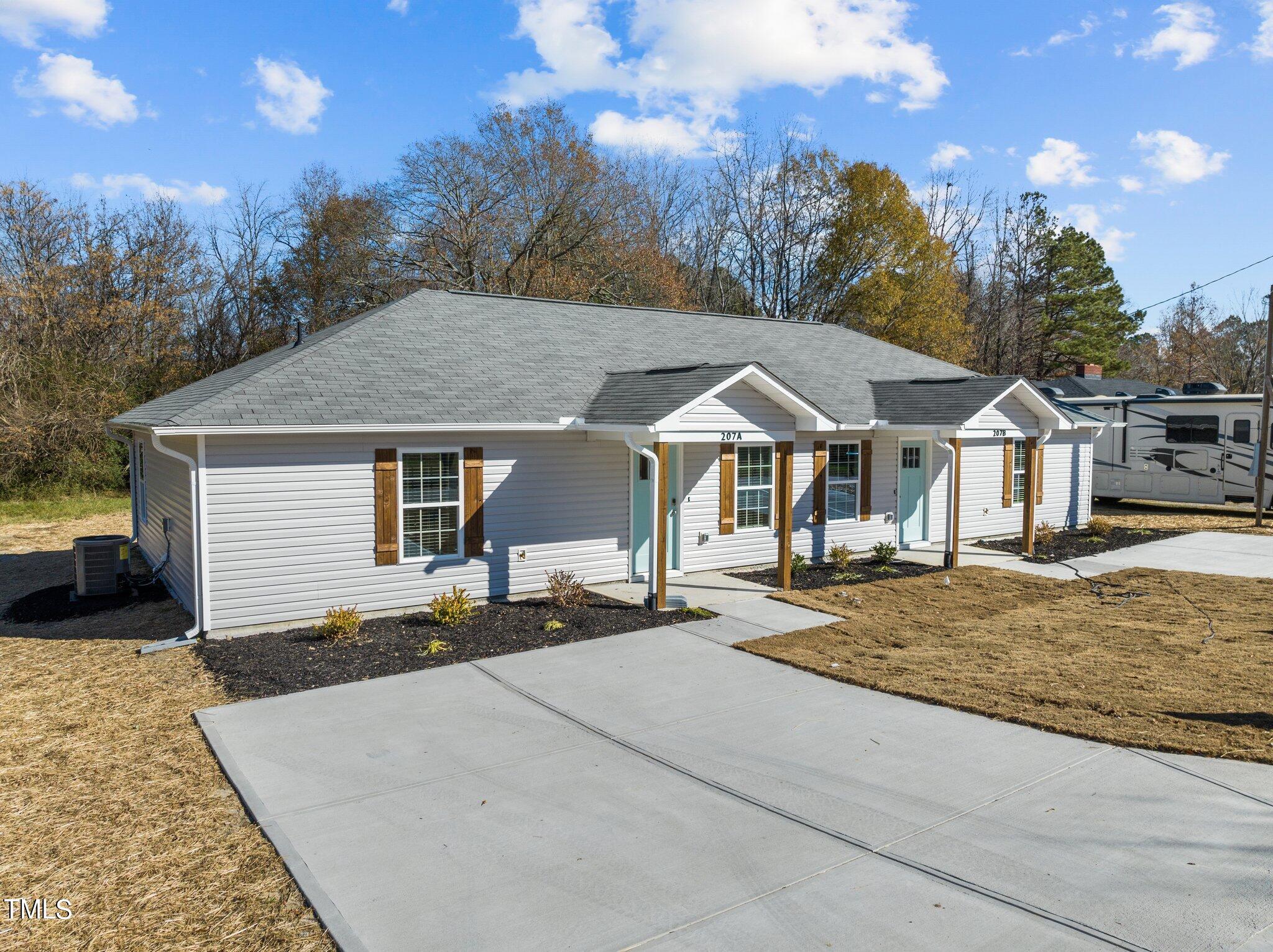 207 South Nash Street, Unit AB Bunn, NC 27508 - Photo 24 of 25 a front view of a house with yard and trees