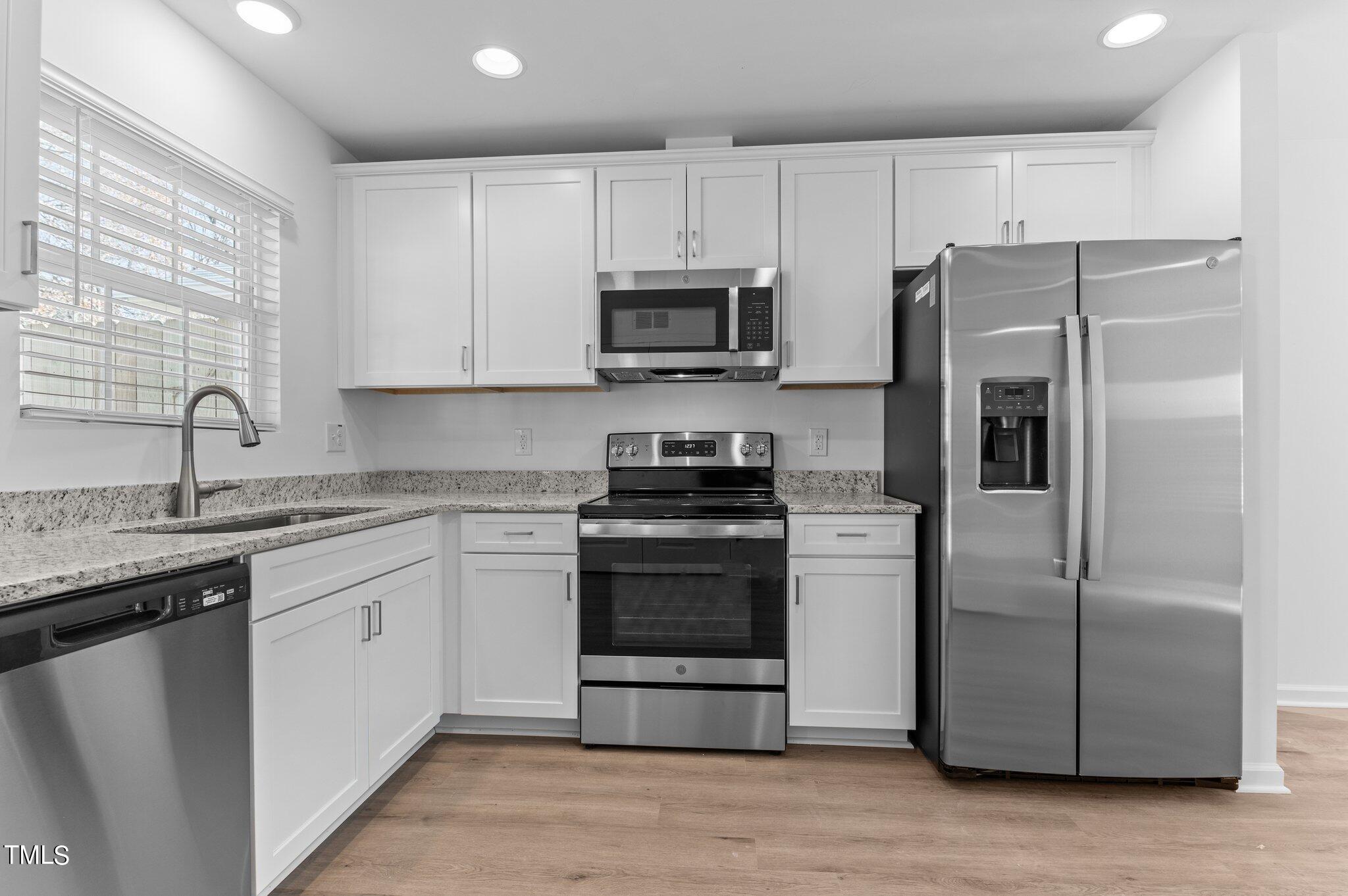 207 South Nash Street, Unit AB Bunn, NC 27508 - Photo 3 of 25 a kitchen with stainless steel appliances granite countertop a refrigerator sink and stove