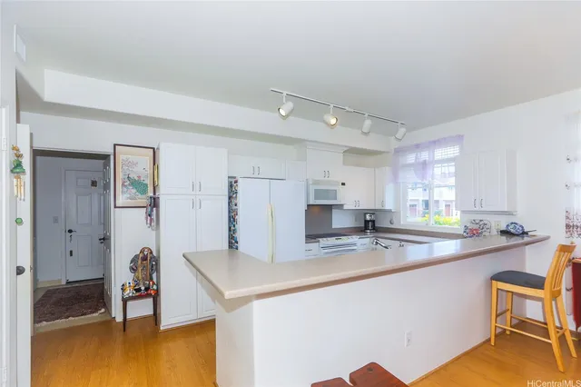 a kitchen with a sink cabinets and wooden floor