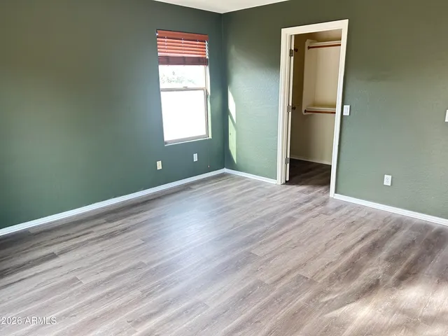a view of empty room with window and wooden floor