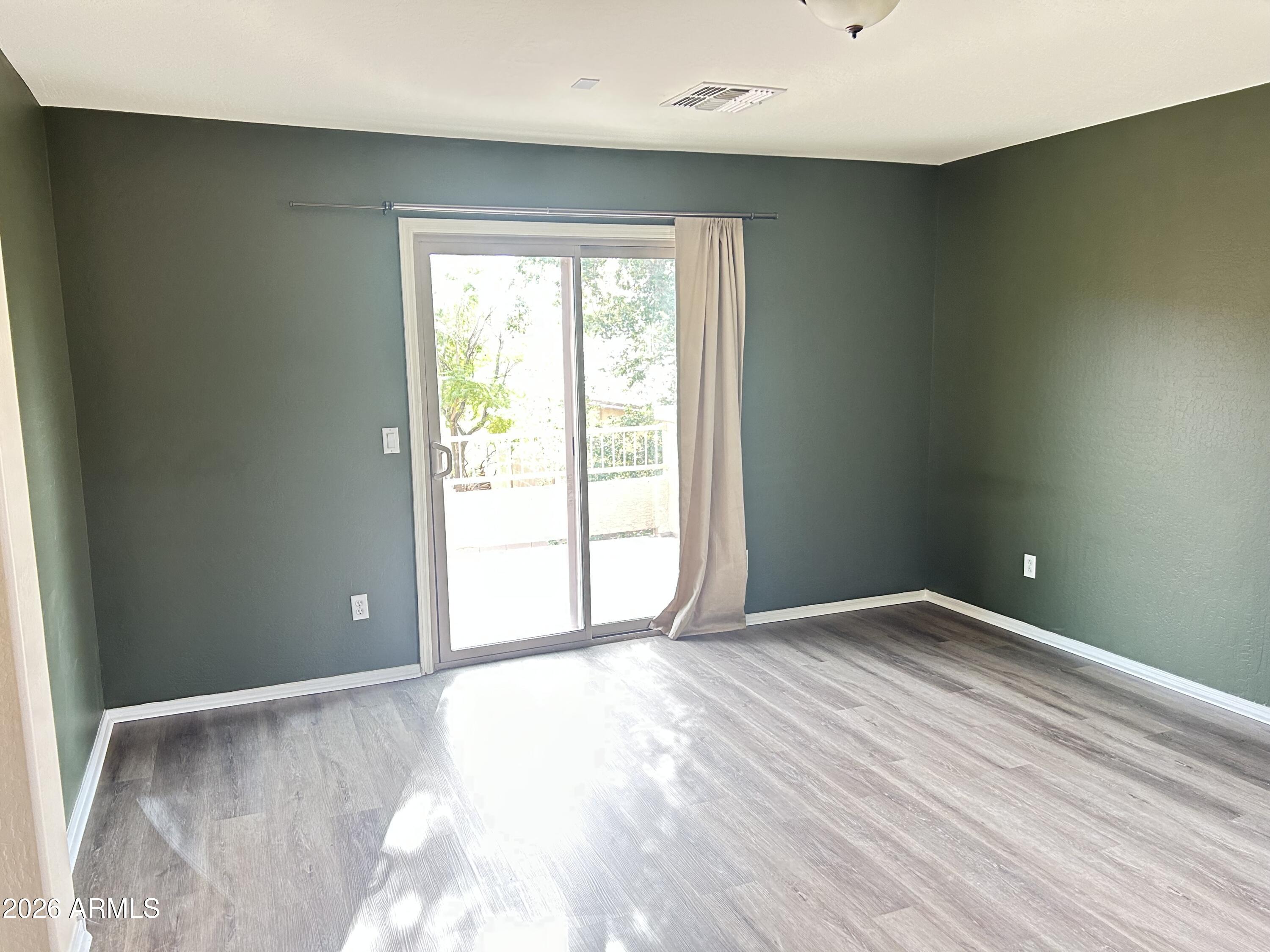 7089 West Eagle Ridge Lane Peoria, AZ 85383 - Photo 23 of 27 a view of an empty room with wooden floor and a window