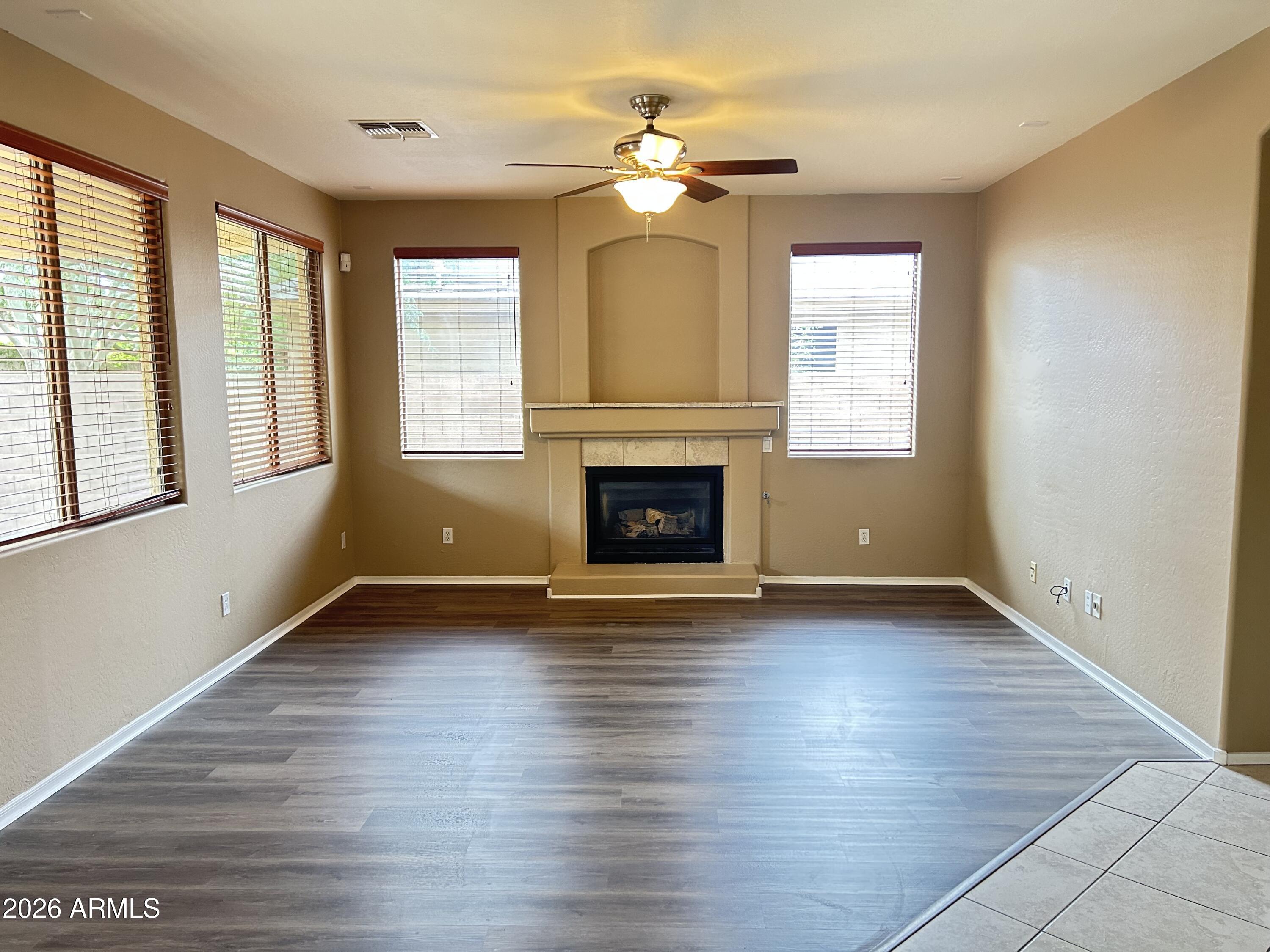 7089 West Eagle Ridge Lane Peoria, AZ 85383 - Photo 27 of 27 an empty room with wooden floor fireplace and windows
