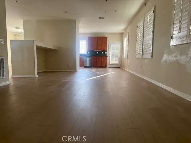 a view of empty room with wooden floor and window