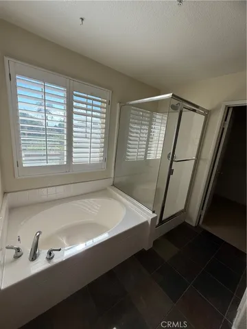 a bathroom with a tub a sink and a window