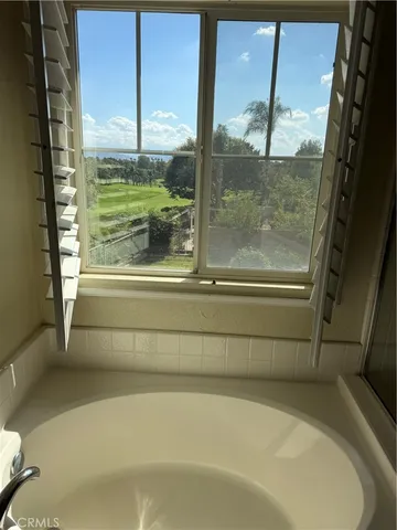 a bathroom with a bathtub and next to a window