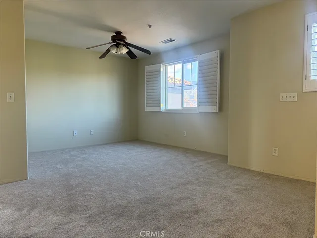 an empty room with a ceiling fan and a window