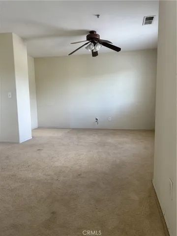 an empty room with a ceiling fan and a window