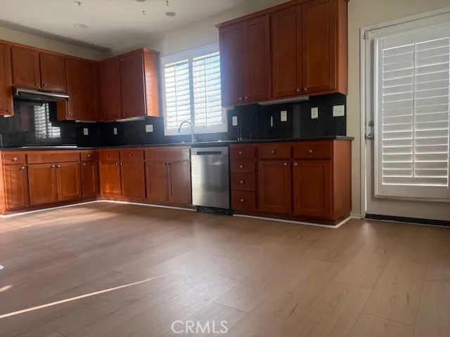 a view of kitchen with granite countertop cabinets and window