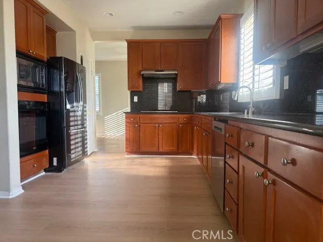 a kitchen with stainless steel appliances granite countertop a refrigerator a sink and a stove