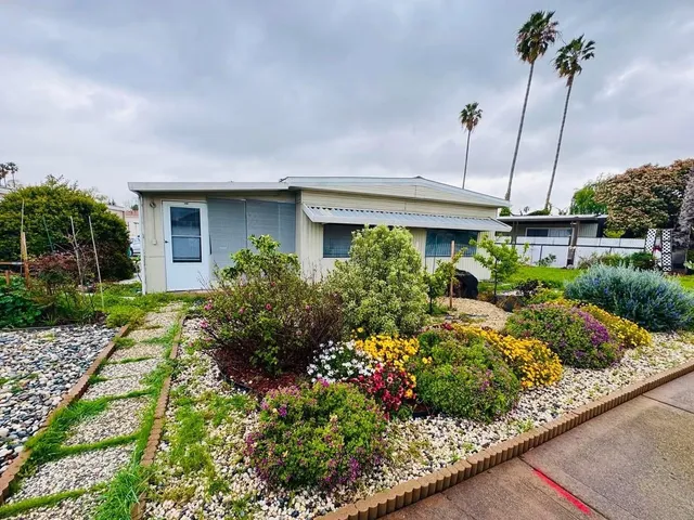 a front view of a house with a yard and potted plants