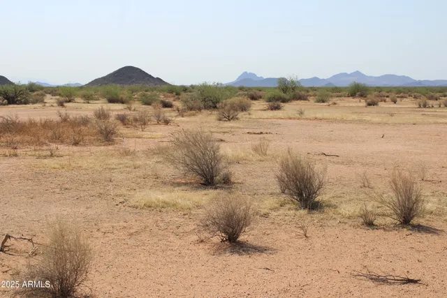 a view of mountain with sunset in background