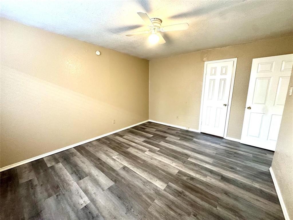 13357 Kit Lane Dallas, TX 75240 - Photo 22 of 26 Spacious room featuring wood-finish flooring, neutral-toned walls, and white baseboards