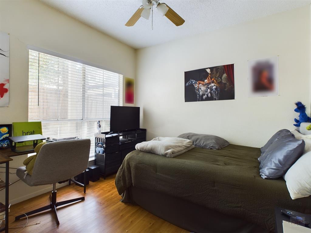 2313 Longview Street, Unit 102 Austin, TX 78705 - Photo 7 of 14 a bedroom with a bed and a computer on a desk