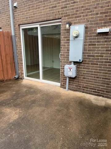 a view of a brick wall and potted plants in front of door