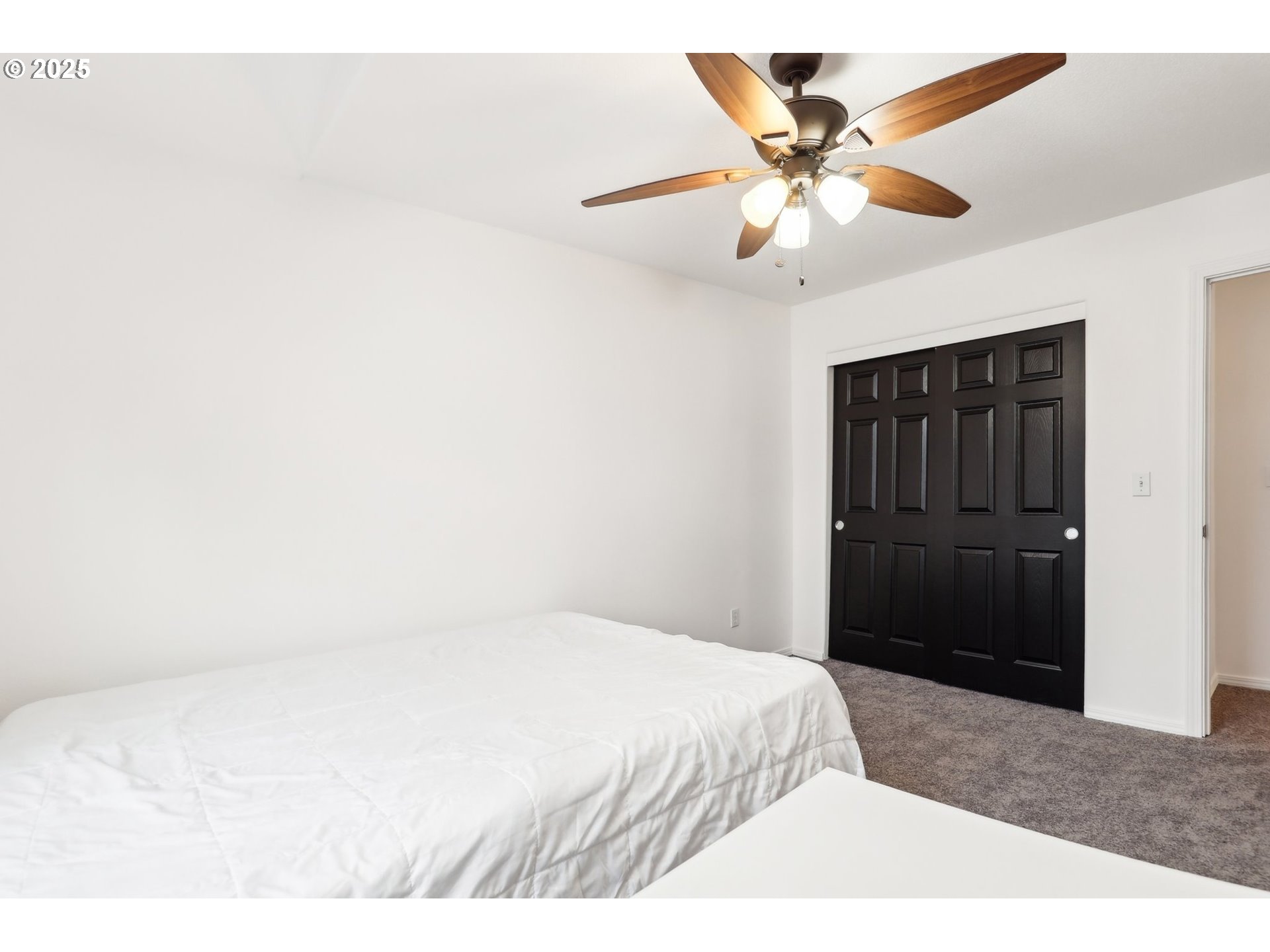 19153 Southeast Yamhill Street, Unit 21 Portland, OR 97233 - Photo 13 of 22 a bedroom with a bed and a ceiling fan