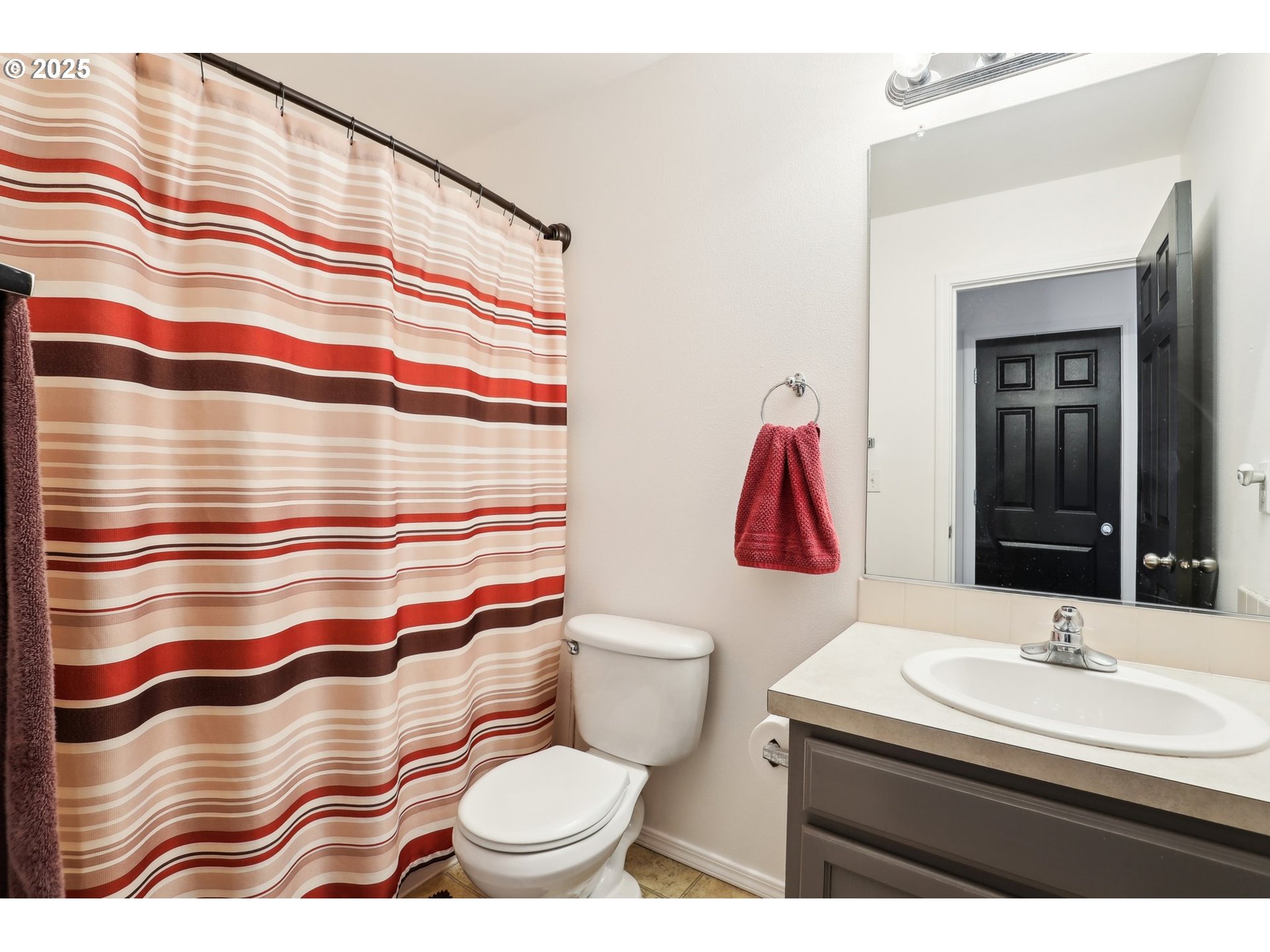 19153 Southeast Yamhill Street, Unit 21 Portland, OR 97233 - Photo 18 of 22 a bathroom with a sink a toilet and shower curtain