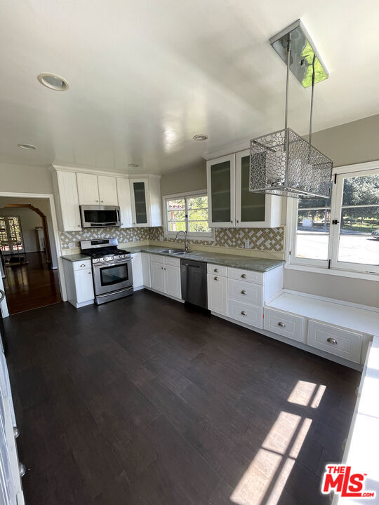 23 Melrose Avenue Pasadena, CA 91105 - Photo 7 of 15 a kitchen with stainless steel appliances granite countertop a stove a sink dishwasher and a microwave oven with white cabinets