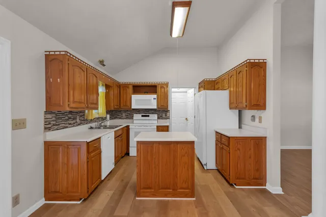 a kitchen with stainless steel appliances a stove top oven a sink and a refrigerator