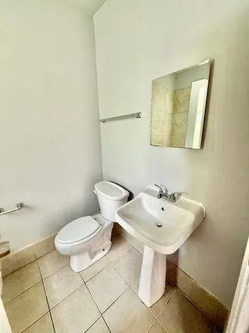 a bathroom with a sink toilet and mirror