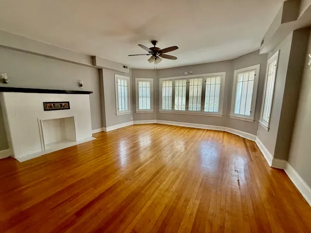 a view of empty room with window and wooden floor