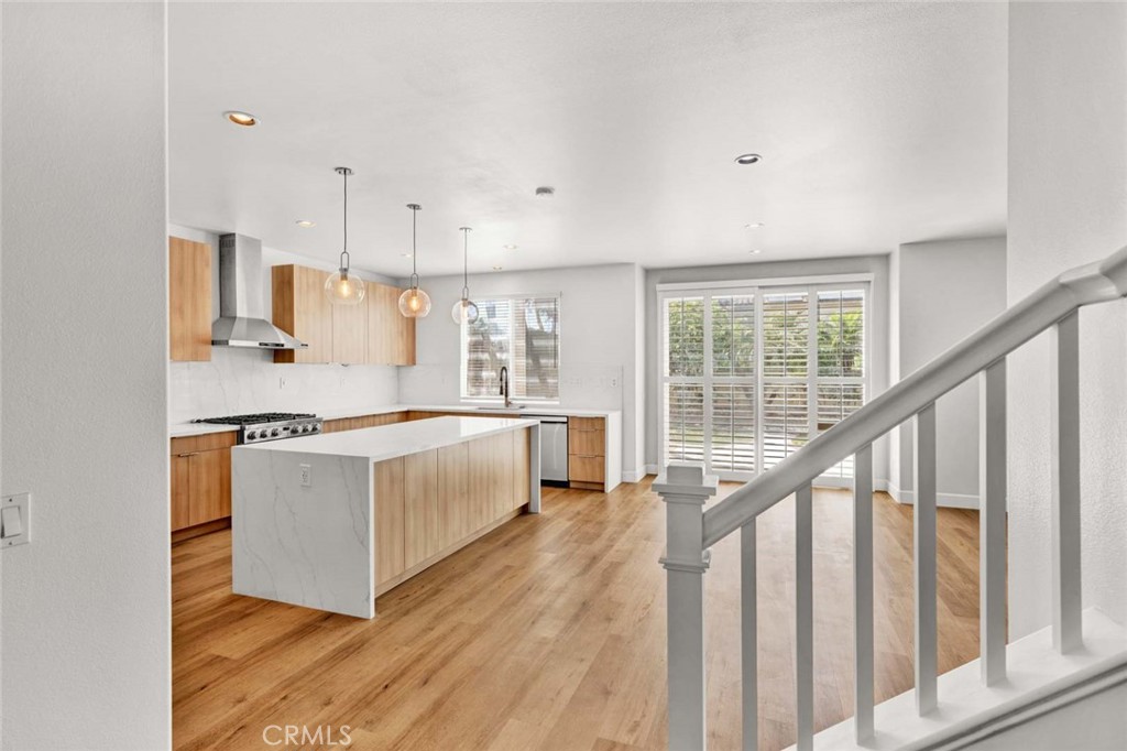 24 Pheasant Creek Irvine, CA 92618 - Photo 13 of 43 a large white kitchen with wooden floor and a window