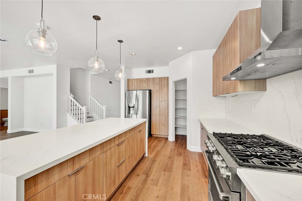 24 Pheasant Creek Irvine, CA 92618 - Photo 7 of 43 a kitchen with stainless steel appliances granite countertop a stove a sink a refrigerator and a wooden floor