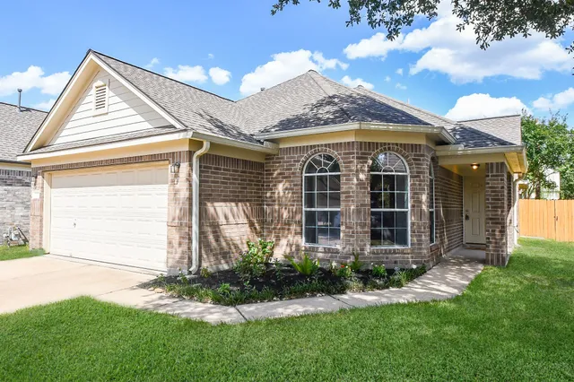 a front view of a house with a garden and plants
