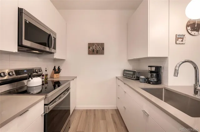 a bedroom with a bed and a flat tv screen on a dresser