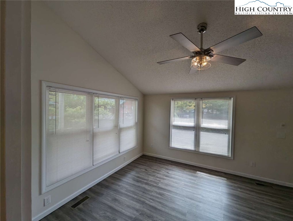 25 Meadow Loop Newland, NC 28657 - Photo 21 of 35 an empty room with wooden floor chandelier fan and windows