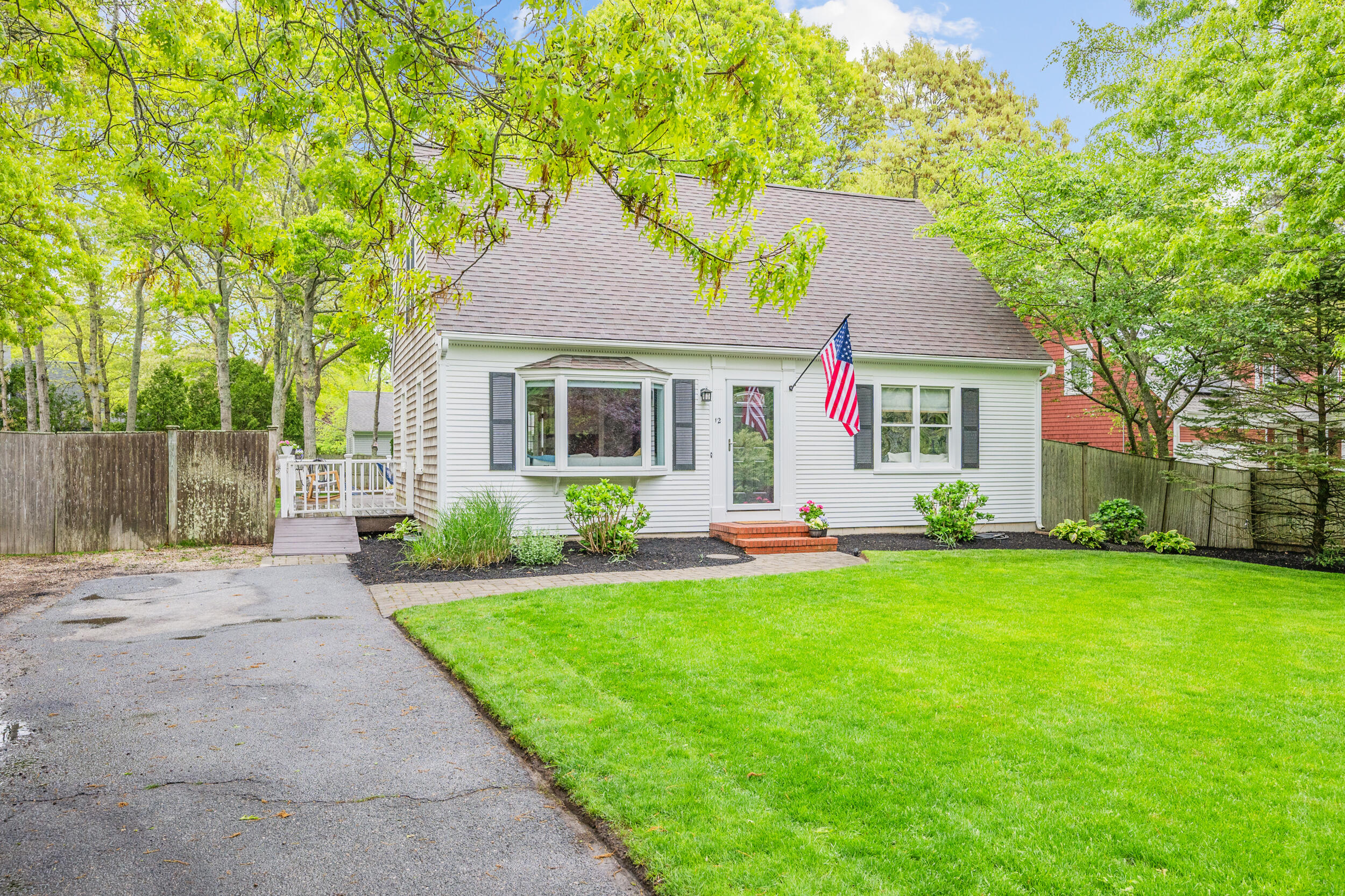 a front view of a house with a yard and trees
