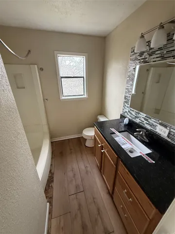 a kitchen with a stove and a wooden floor
