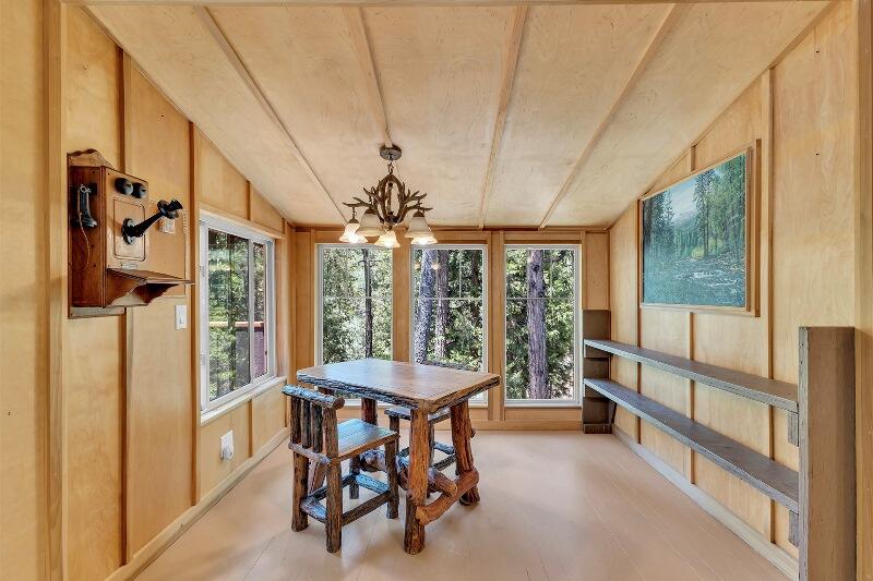 27240 Saunders Meadow Road Idyllwild, CA 92549 - Photo 18 of 51 a dining room with furniture a chandelier and a wooden floor